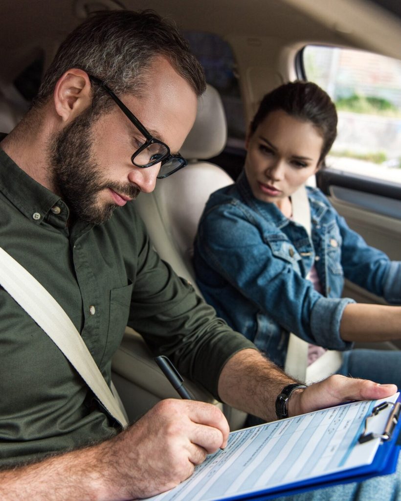 teacher-writing-something-to-clipboard-during-driving-test.jpg